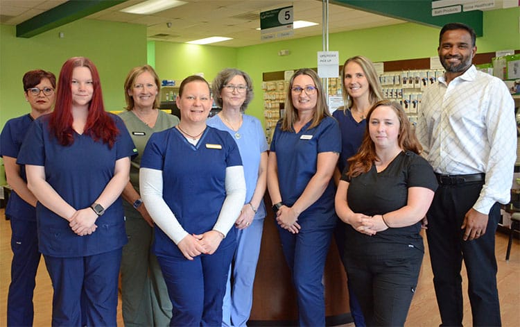 Image of the nine people that make up the Dan's Wellness Pharmacy staff with the owner and pharmacist Krishna Gondi on the far right and the 8 pharmacy techs to his left.